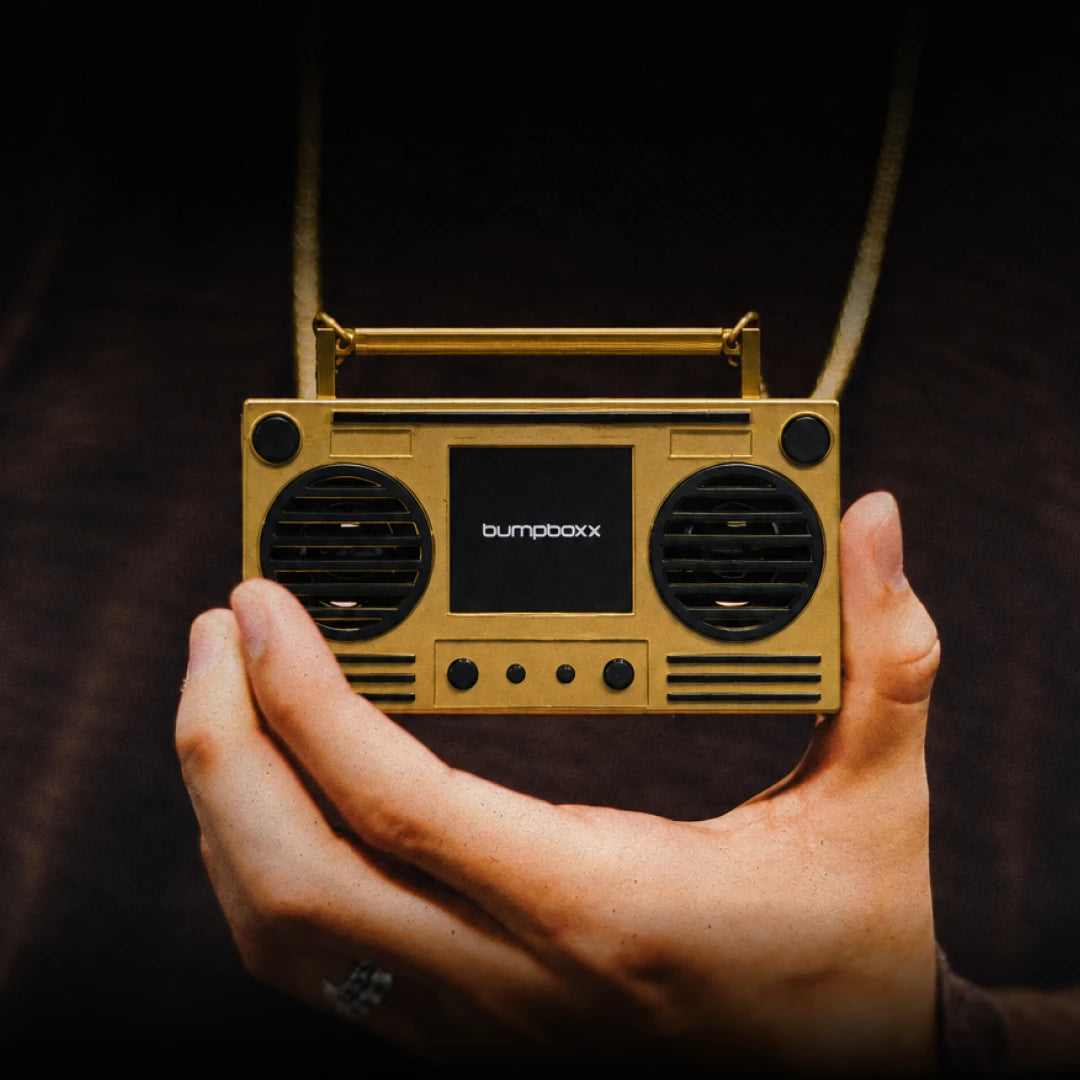 Gold Microboom held in a hand, hanging on its chain